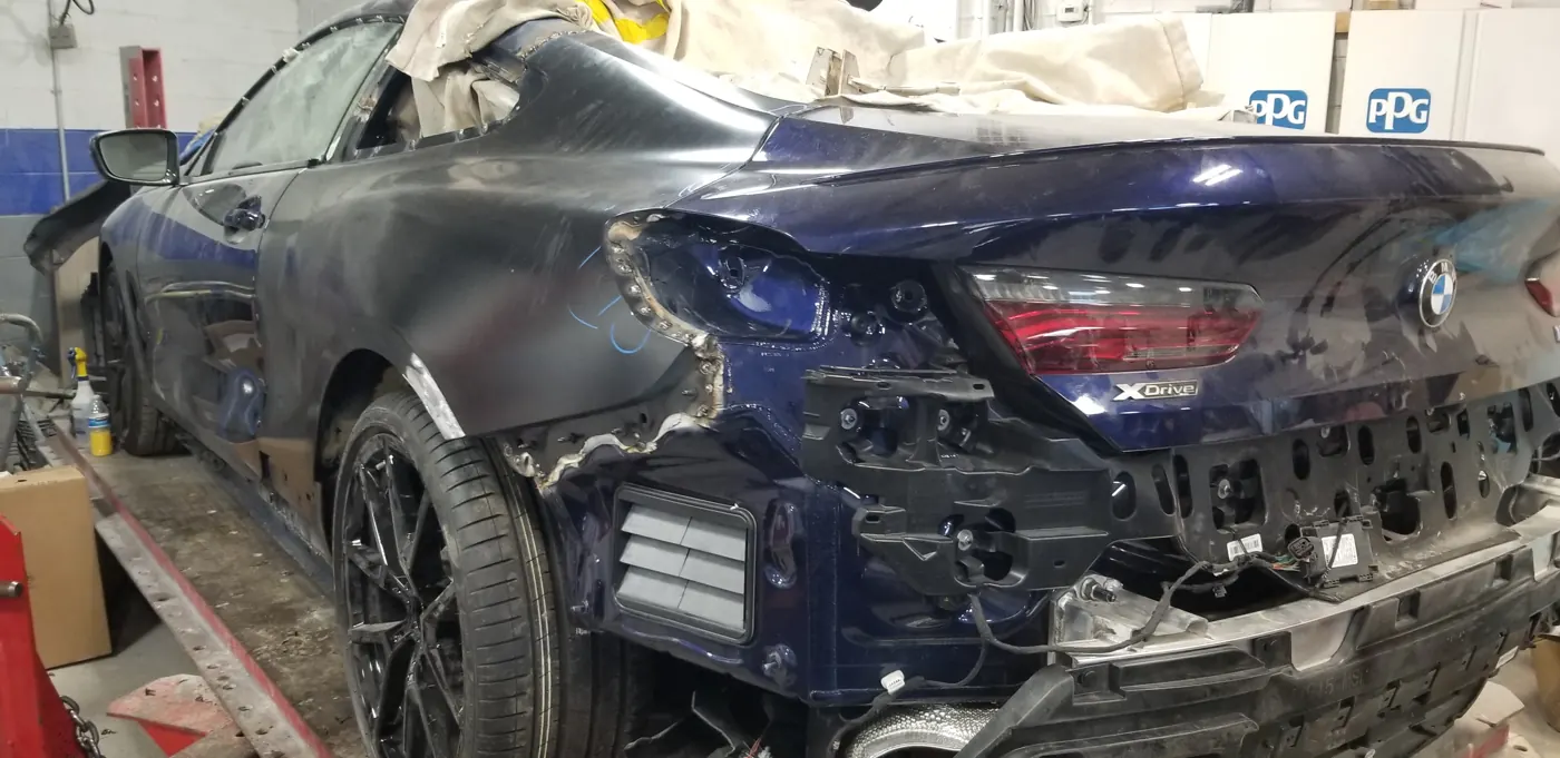 BMW 8 Series with heavy rear-quarter and bumper damage, before repair