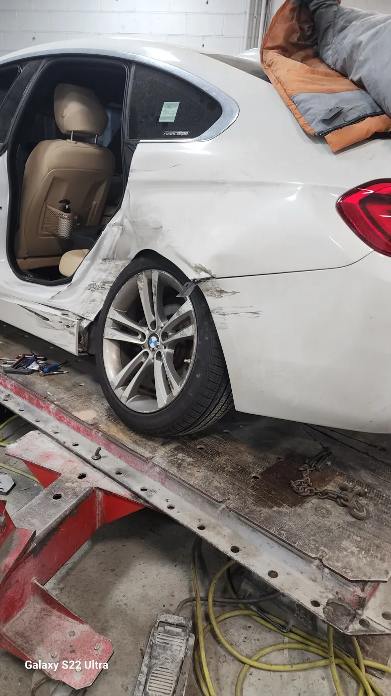 White BMW on the frame bench for structural collision repair