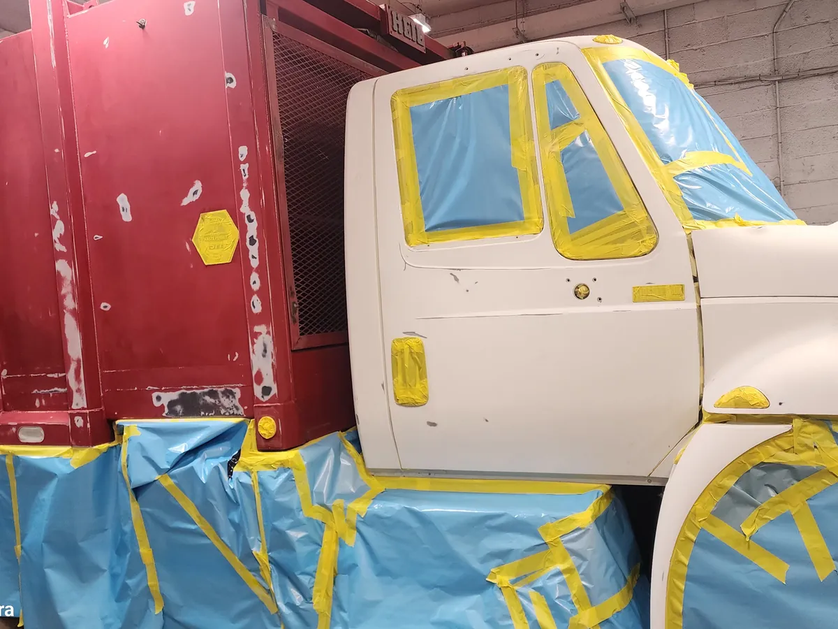 Commercial truck masked for refinishing in the First Class Collision paint booth