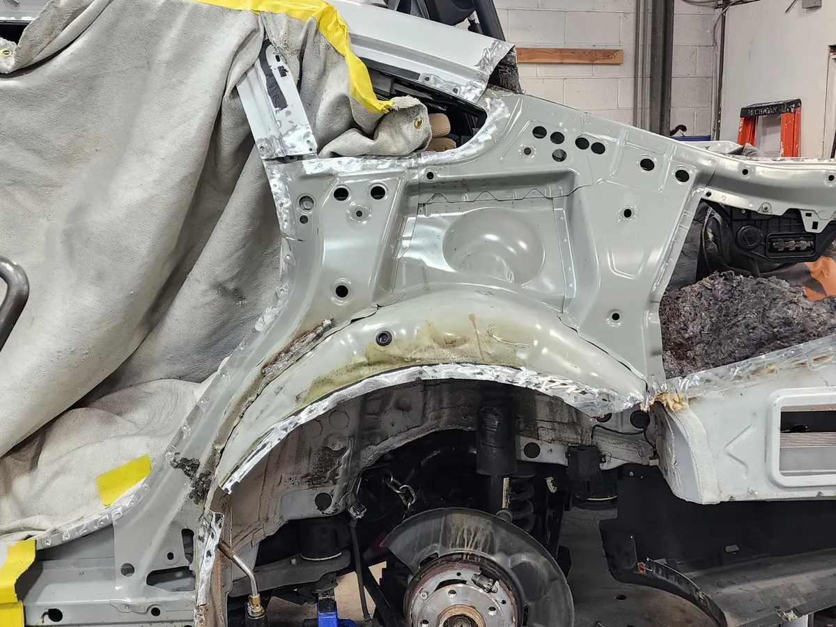 Structural collision repair in progress on the frame machine at First Class Collision